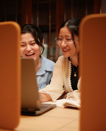 CnC team members laughing over a laptop